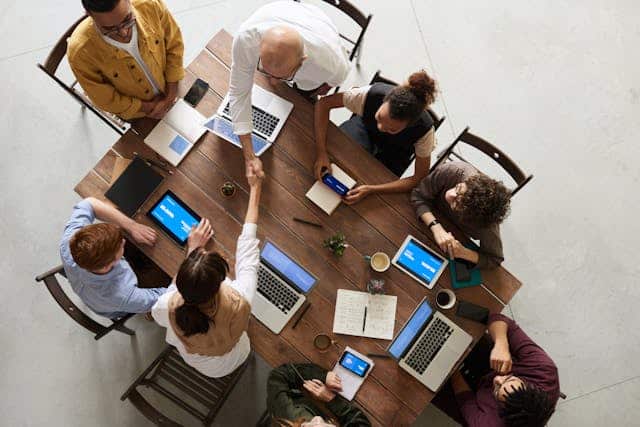 A group of colleagues sitting and working with their laptops in front of each other