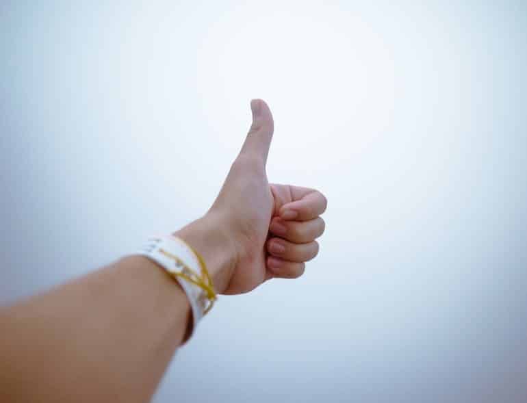 a close-up of a hand showing thumbs up